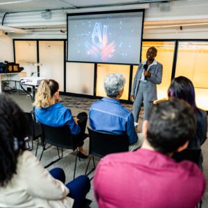 Man presenting AI lecture to seated audience.