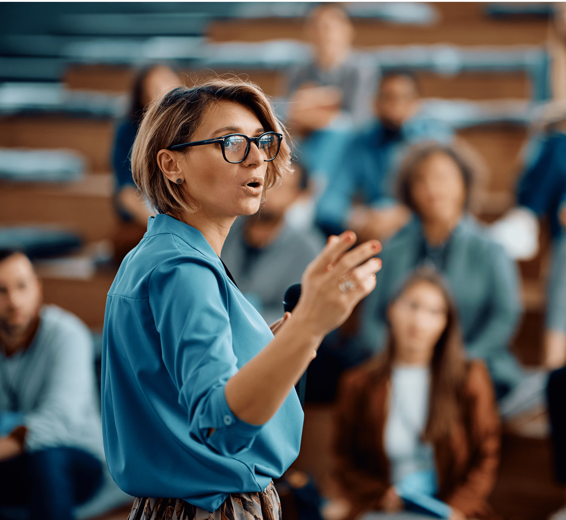 Speaker addressing audience in a lecture hall.